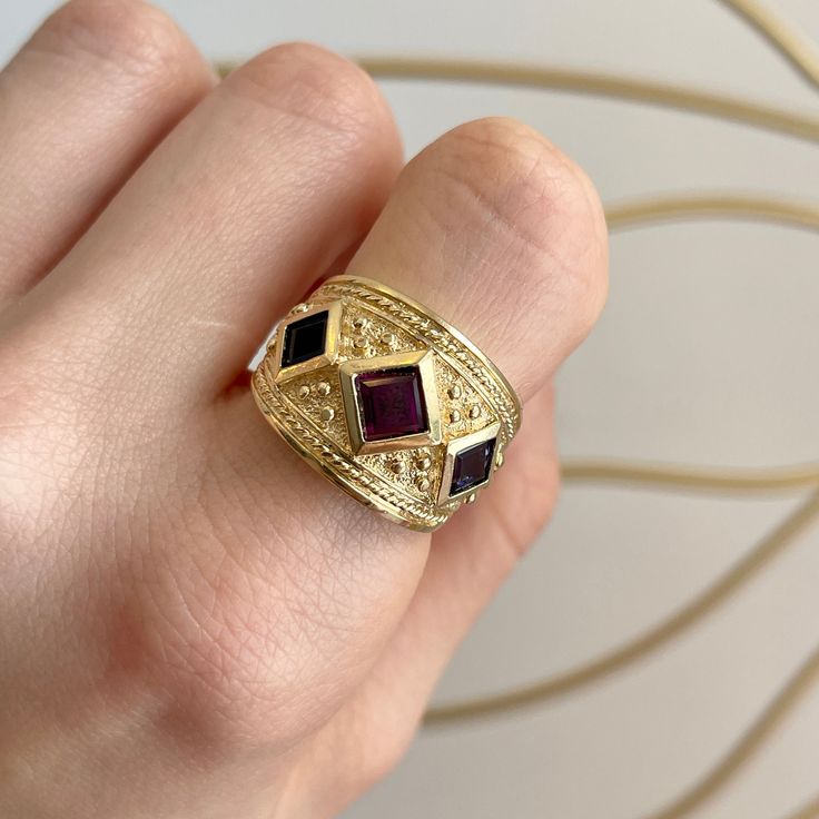 14KT yellow gold Byzantine/ Etruscan design, textured matte-finish, artistic, cigar band ring with genuine, square amethyst + blue Iolite gemstones. New and can be customized (additional fees apply). (2) Square Iolite (1) Square Amethyst Size: 7 But can be sized and made to order in other sizes, and with other gemstones Tapered back, but flat finished inside Measures: 15mm Wide~ Graduated Back to 4mm Weighs: 9 Grams Byzantine Fashion, Etruscan Jewelry, Byzantine Rings, Byzantine Jewelry, Cigars, Vintage Jewellery, Band Rings, Jewelry Accessories, Amethyst