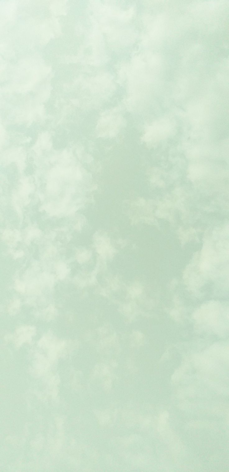 an airplane flying through the sky with clouds in the backgrounnd and light green