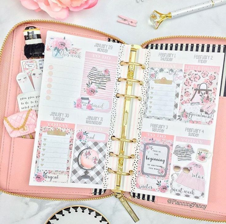 an open planner book sitting on top of a table next to a plate and flowers