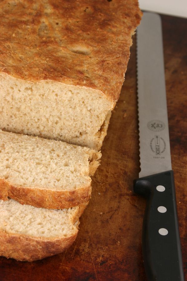 sliced loaf of bread sitting on top of a cutting board next to a knife