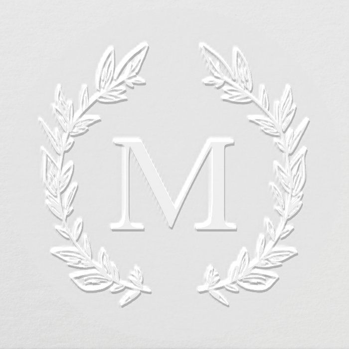 the letter m is made out of paper with leaves and branches around it, on top of