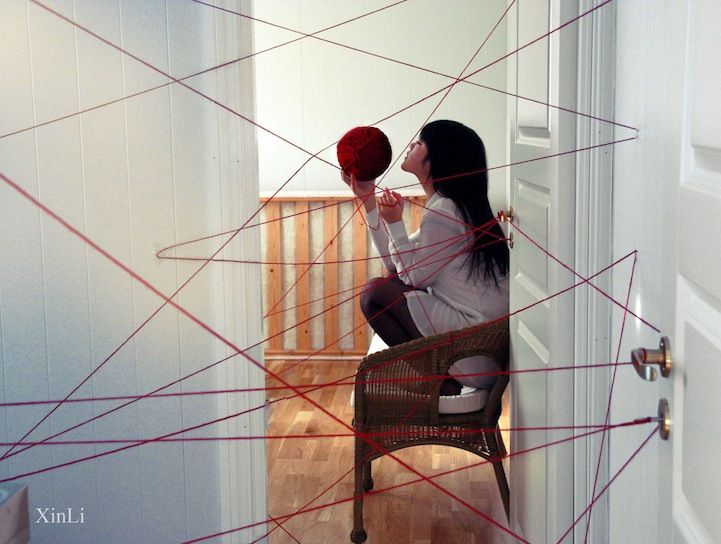 a woman sitting on a chair holding a basketball in front of her face with red thread