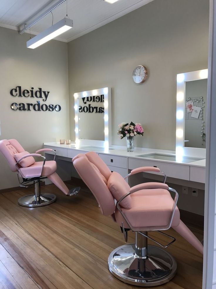 a hair salon with pink chairs and mirrors