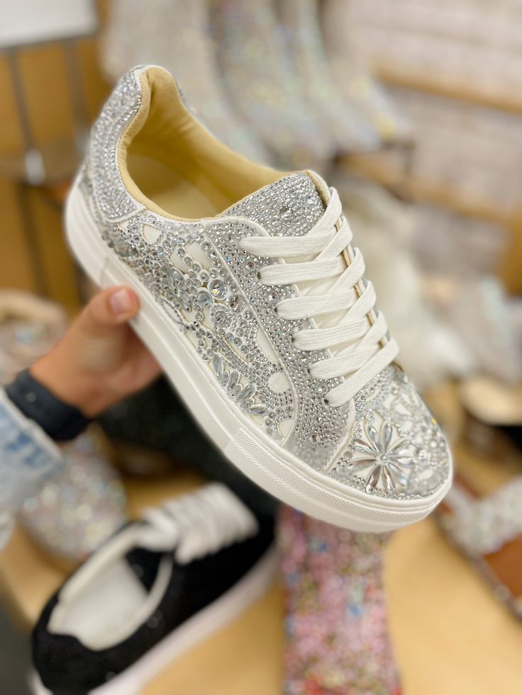 Put a little sparkle in your step with the REILY rhinestone sneakers. This sneaker can be paired with your best dress or favorite jean! Its intricate pattern is an eye-catching way to make a statement, no matter where you're wearing it. Manmade rhinestone platform sneakers Lace up closure Textile lining Rubber sole 1.5 inch platform Imported Luxury Party Sneakers With Glitter Accents, Trendy Sparkling Lace-up Sneakers, Casual Sneakers With Rhinestones And Round Toe, Trendy Low-top Rhinestone Sneakers, Trendy Low-top Sneakers With Rhinestones, Low-top Sneakers For Spring Parties, Trendy Rhinestone Low-top Sneakers, Casual Low-top Sneakers With Rhinestones, Spring Party Low-top Sneakers