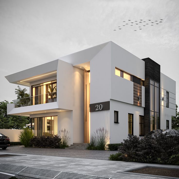 a modern house with white walls and black trim on the front door is lit up at night