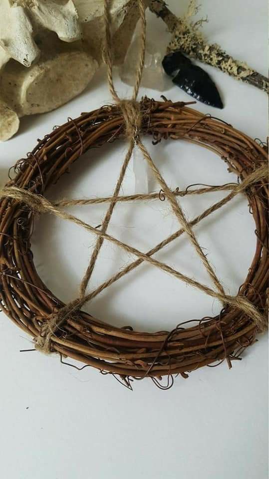 a wicker pen and some other items on a white table with a star ornament hanging from it