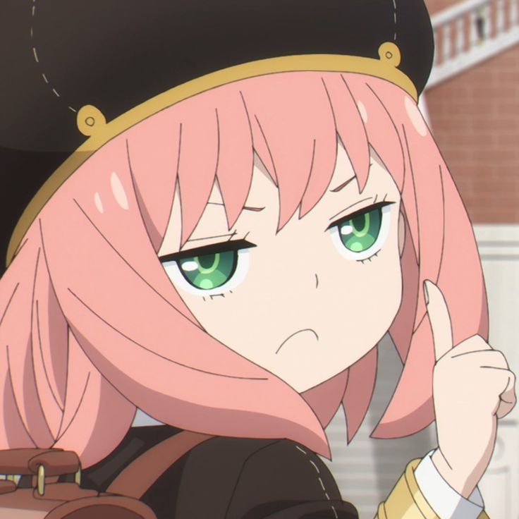 a girl with pink hair and green eyes wearing a black hat is pointing at the camera