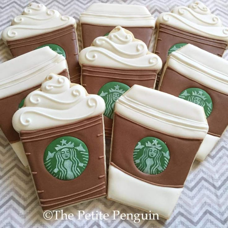 starbucks cup cookies with white frosting and chocolate icing are on a tablecloth