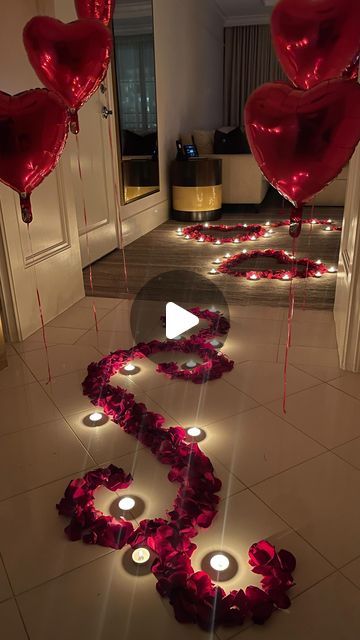 valentine's day decorations on the floor with candles and heart - shaped balloons in the middle