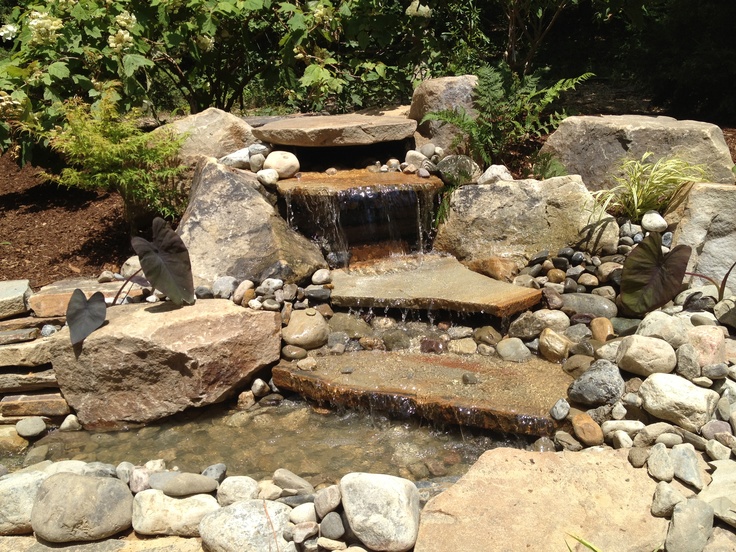 there is a small waterfall in the middle of some rocks