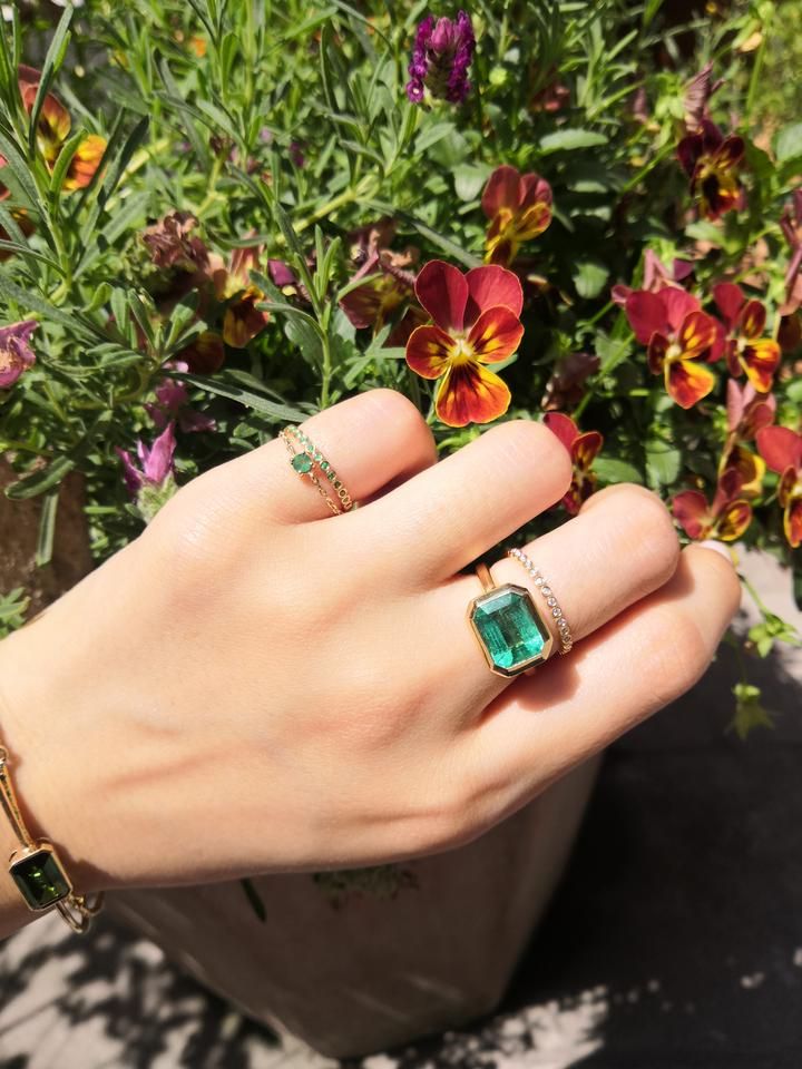 This is our newest emerald creation. This graphic and linear ring is simply spectacular. A dazzling emerald of enviable size is bezel set to perfection in 18k gold. The cool lines of this ring allows for the central emerald to shine through. Each of our emeralds have been meticulously hand-selected. This is a prime exa Fine Jewelry Green Radiant Cut Diamond Ring, Green Radiant Cut Diamond Ring Fine Jewelry, Green Radiant Cut Diamond Ring, Timeless Green Jewelry With Bezel Setting, Fine Jewelry With Channel Set Green Stones, Fine Jewelry Green Channel Set, Green 14k Gold Jewelry With Bezel Setting, Modern Green Rings With Prong Setting, Fine Green Jewelry With Channel Set