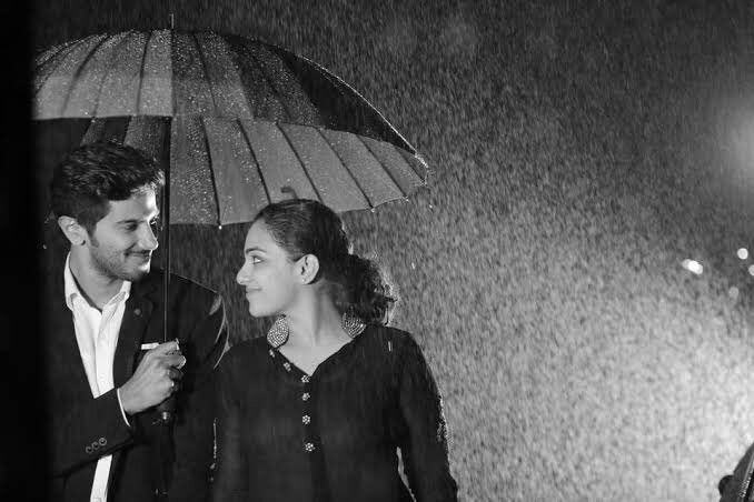 a man and woman standing under an umbrella in the rain