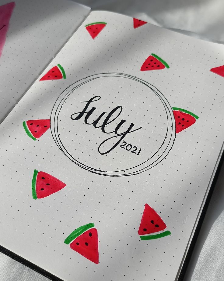 an open notebook with watermelon stickers on it and the word july written in black ink