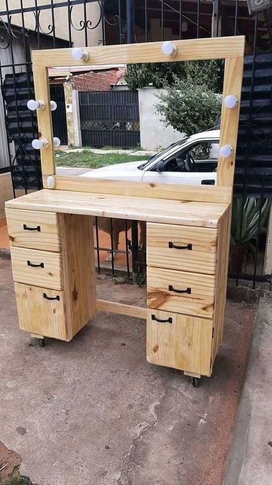 a wooden desk with drawers and a mirror on the top of it in front of a house