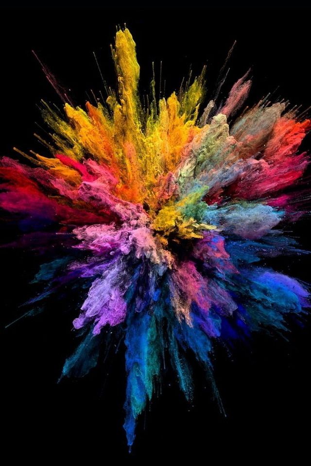 colored powder is flying in the air on a black background with space for text or image