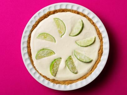 a white plate topped with a pie covered in lime slices