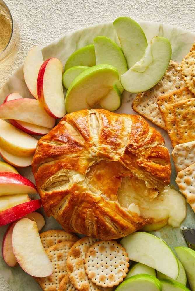 an apple and cheese platter with crackers, apples, and croissants