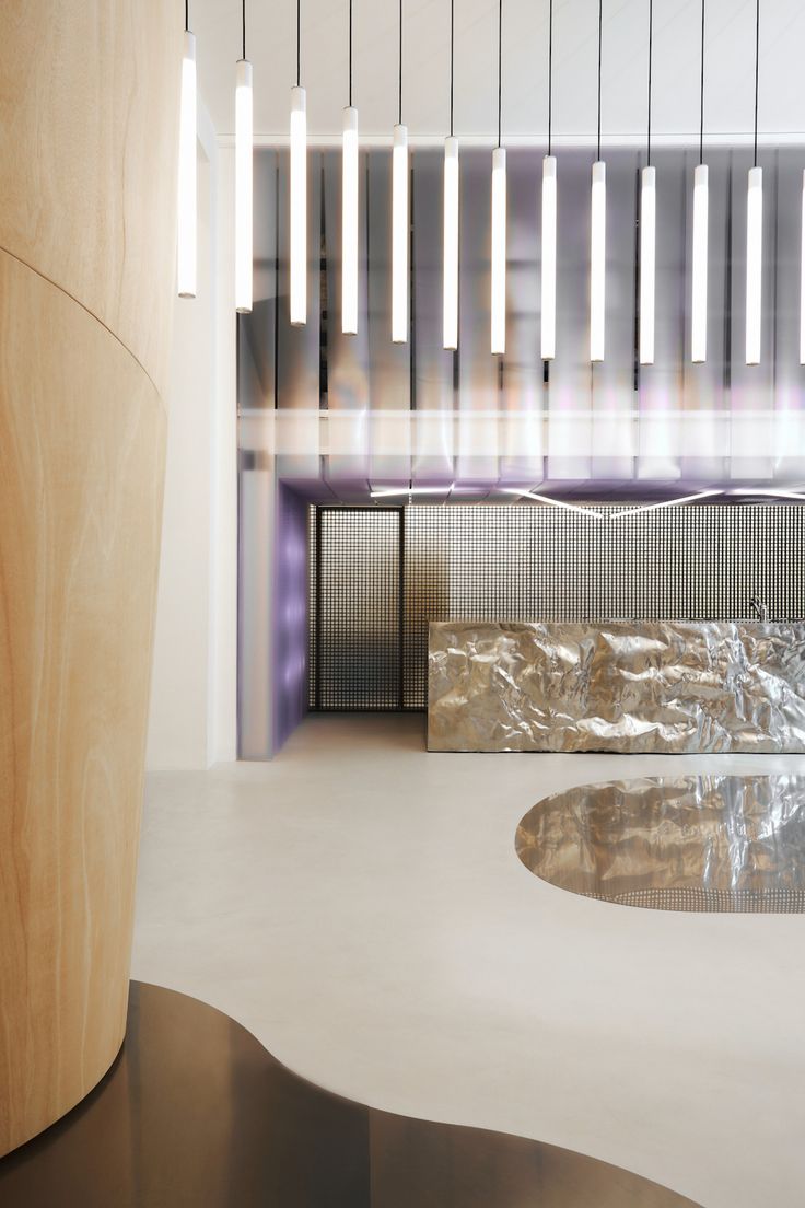 the interior of an office building with modern lighting fixtures and marble counter tops in front of a circular window