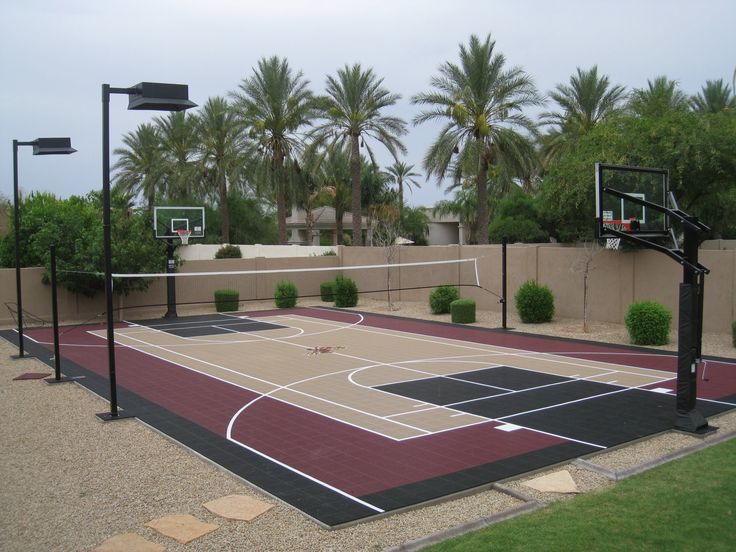 an outdoor basketball court surrounded by palm trees