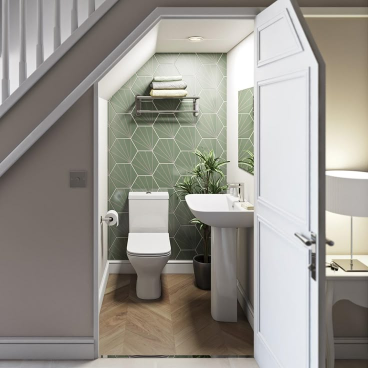 an open door leading to a bathroom with green tiles on the walls and flooring