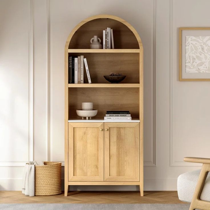 a wooden book shelf with books on it in a living room next to a chair