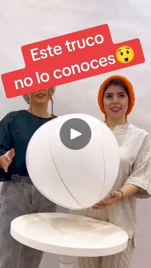 two people holding up a large white object in front of a sign that says est truco no lo conoces