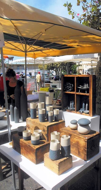 several vases are on display under an umbrella