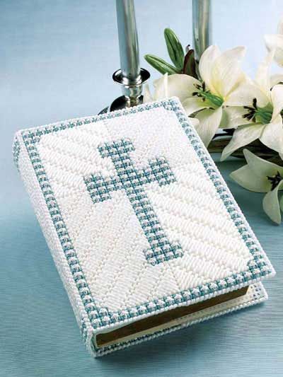 a cross is on top of a book next to some flowers