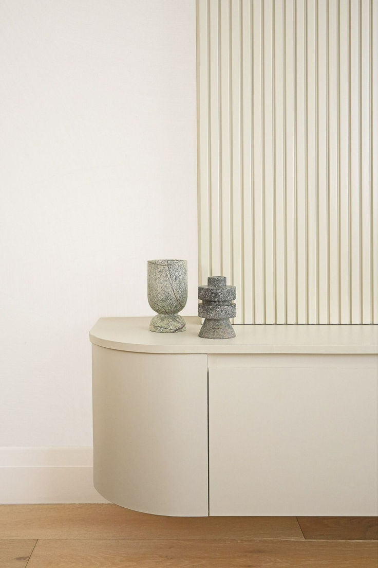 two vases sitting on top of a white cabinet