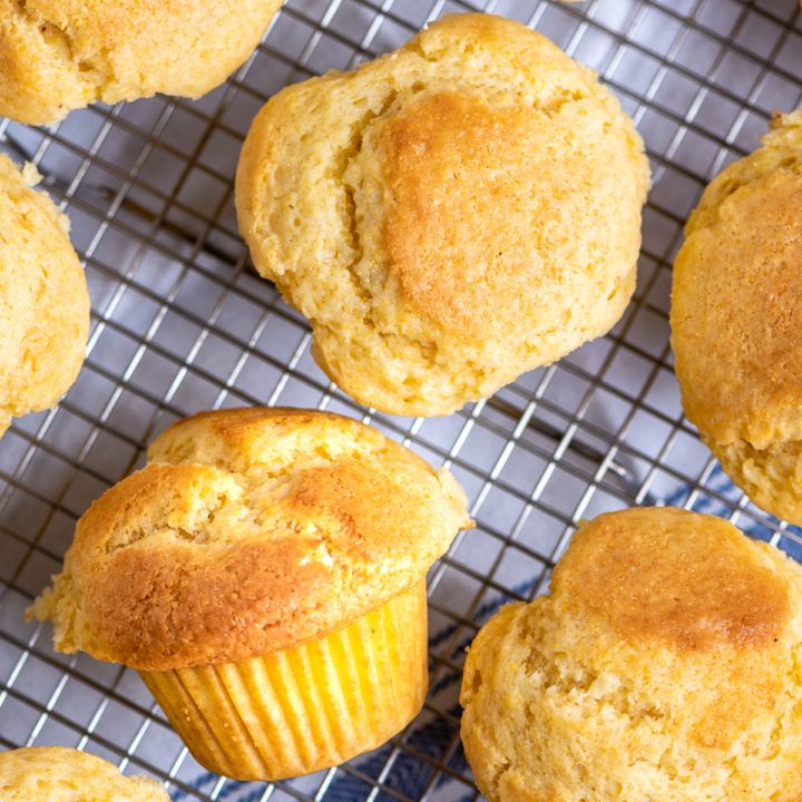 several muffins cooling on a wire rack with one muffin in the middle