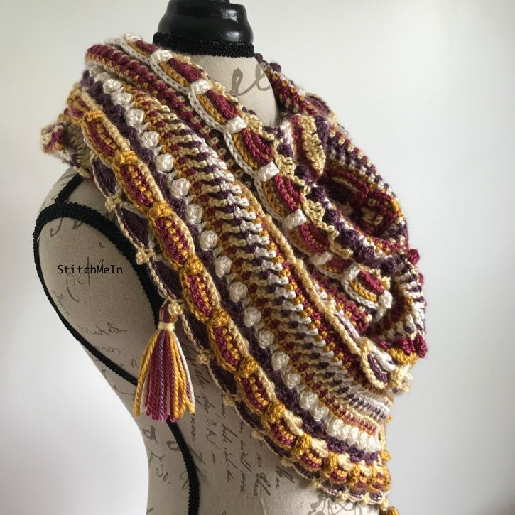 a close up of a mannequin wearing a multicolored crocheted scarf