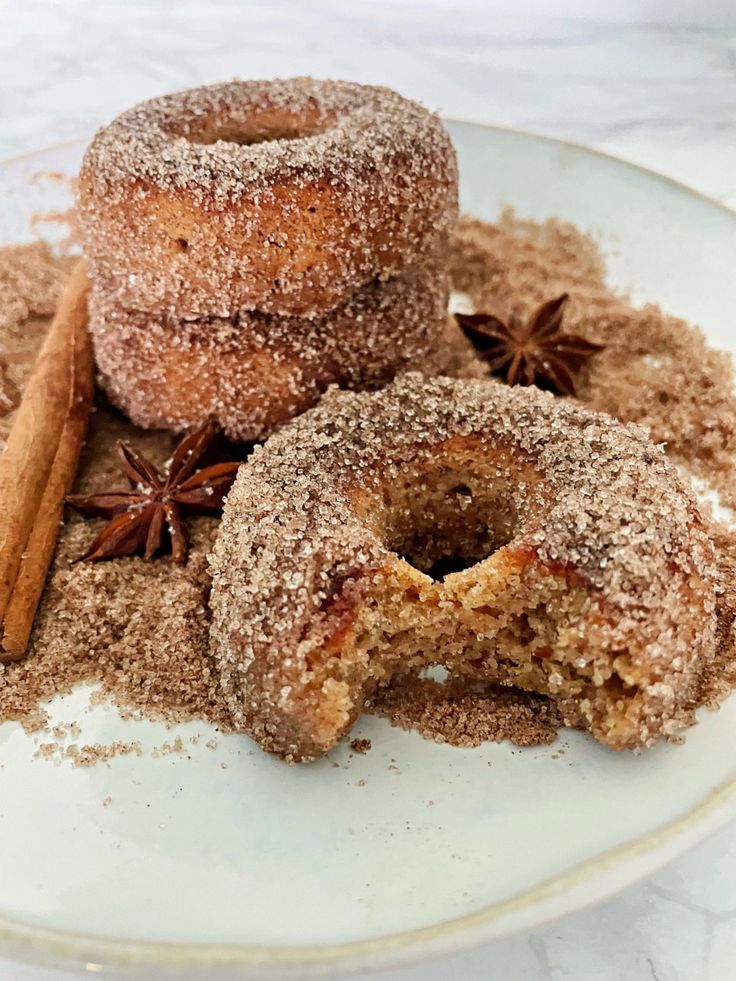 cinnamon sugar doughnuts on a plate with cinnamon and star anise