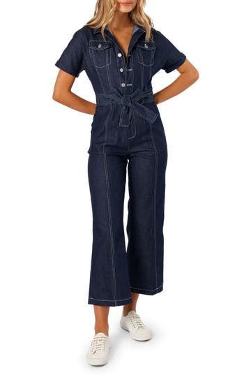 Contrast stitching heightens the utilitarian style of a short-sleeve denim jumpsuit cinched with a matching tie belt. Front button closure Spread collar Short sleeves Chest button-flap patch pockets; front slant pockets; back patch pockets Removable tie belt Unlined 100% cotton Hand wash, dry flat Imported Spring Short Sleeve Utility Denim Jumpsuit, Spring Utility Denim Jumpsuit With Short Sleeves, Utility Short Sleeve Denim Jumpsuit With Pockets, Short Sleeve Denim Utility Jumpsuit For Workwear, Summer Denim Jumpsuit With Button Closure And Short Sleeve, Short Sleeve Denim Jumpsuit For Work, Utility Denim Jumpsuit With Short Sleeves And Pockets, Utility Denim Jumpsuit With Pockets And Short Sleeves, Utility Style Denim Jumpsuit With Short Sleeves For Work