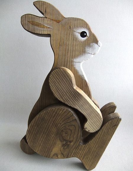 a wooden sculpture of a rabbit sitting on its hind legs