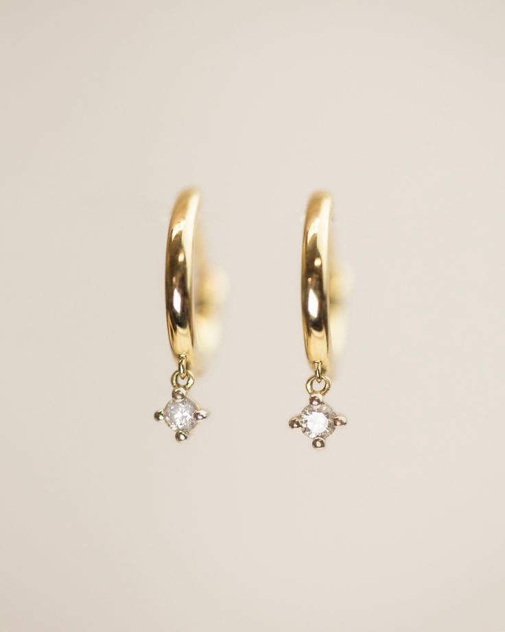 These simple, classic hoops will take your everyday look to the next level. A sparkling diamond drop adorns the discreet hinge for a touch of elegance and shine, and clicks closed securely. Elevate your wardrobe with these timeless and tasteful pieces. #diamondearrings #earrings #jewelry #giftideas Simple Gold Dangle Earrings, Gold Minimalist Jewelry, Dangle Hoop Earrings, Sparkling Diamond, Meaningful Jewelry, Gold Diamond Earrings, Huggie Earrings, Diamond Drops, Huggie Hoop Earrings