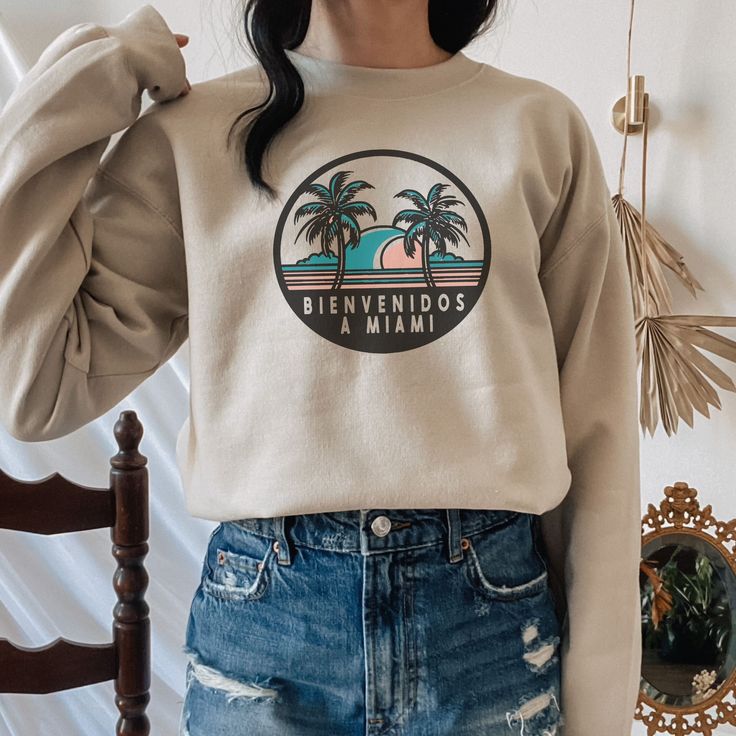 Bienvenidos a Miami, Florida! Get ready to soak up the sun and embrace the vibrant energy of Miami with our Unisex Bienvenidos a Miami Florida Crewneck Sweatshirt! Whether you're lounging on the white sandy beaches of South Beach or exploring the colorful Art Deco architecture in the historic district, this sweatshirt is the perfect blend of style and comfort for your Miami adventures. Made from a cozy polyester and cotton blend, it keeps you feeling relaxed and looking effortlessly cool as you Trendy Summer Leisure Sweatshirt, Summer Graphic Print Sweatshirt With Relaxed Fit, Summer Graphic Print Relaxed Fit Sweatshirt, Relaxed Fit Crew Neck Vacation Top, Relaxed Fit Crew Neck Tops For Vacation, Relaxed Fit Tops For Vacation Loungewear, Vacation Loungewear Tops With Relaxed Fit, Summer Vacation Crew Neck Sweatshirt, Relaxed Fit Sweatshirt For Summer Beach