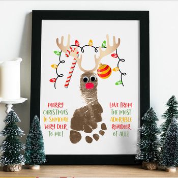 a framed christmas card with a reindeer's handprint and candy canes on it