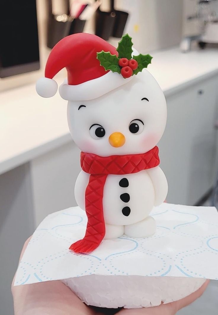 a small snowman with a red hat and scarf