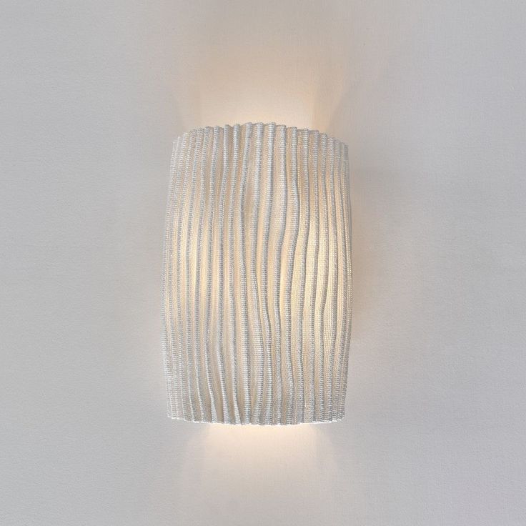 a white wall light mounted on the side of a wall