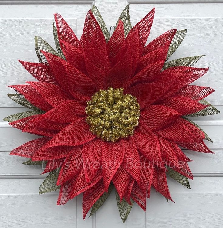 a red and gold mesh flower on a white door