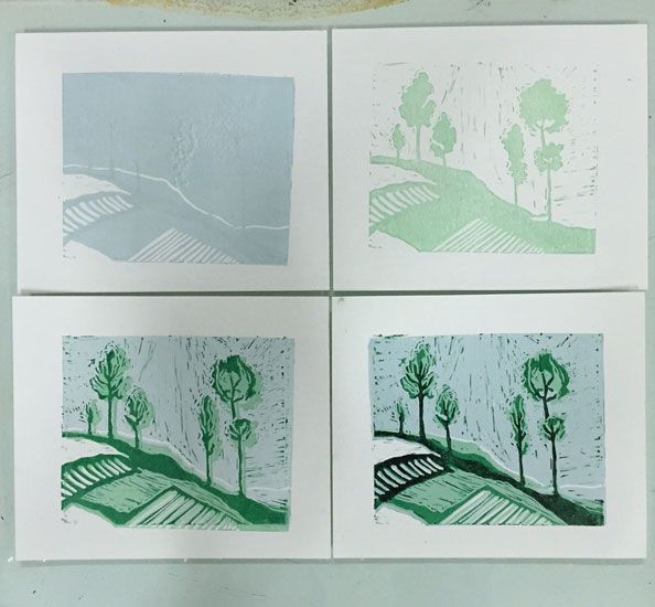 four green and white cards with trees in them on a table next to a wall