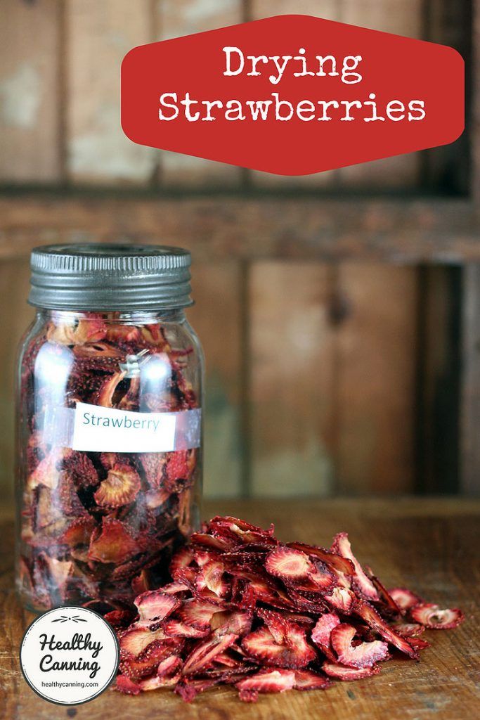 a jar filled with dried strawberries sitting on top of a wooden table