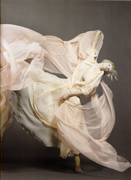 a woman in white dress with flowing fabric