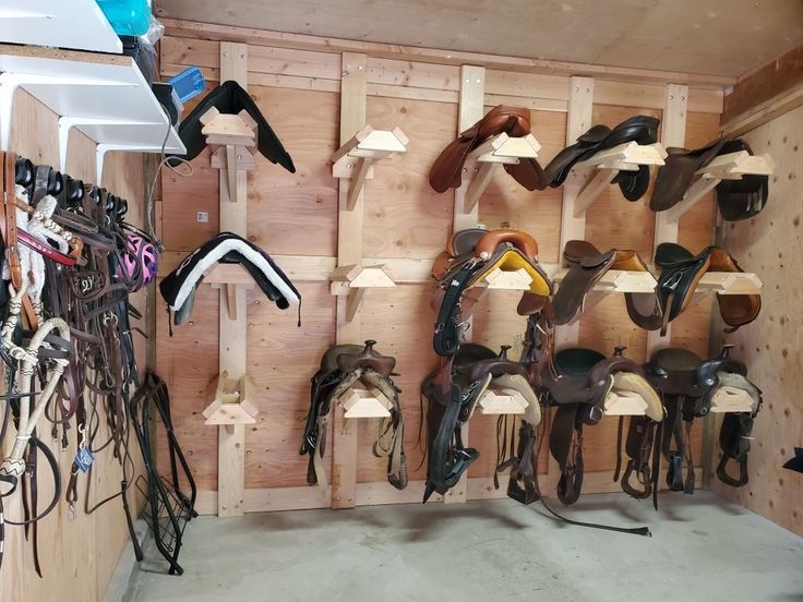 a room filled with lots of different types of saddles and tacks hanging on the wall