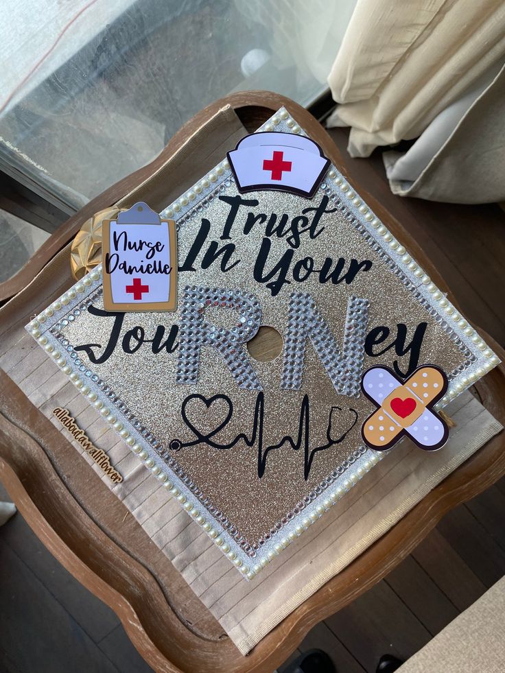 a graduation cap that says trust in your journey with nurse pins on it and an i love you sticker