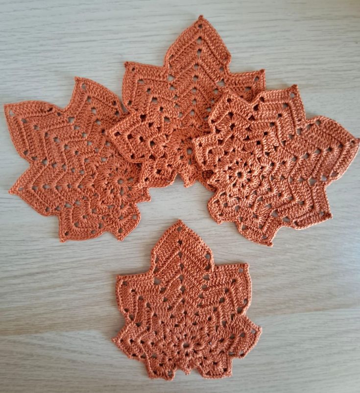 four crocheted doily on a wooden surface