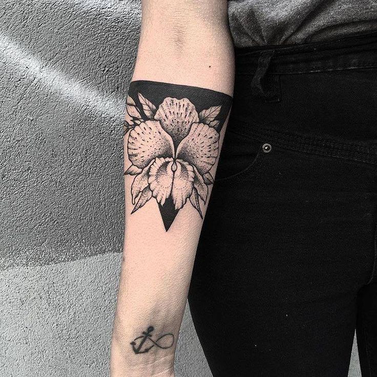 a woman's arm with a flower tattoo on the left side of her arm