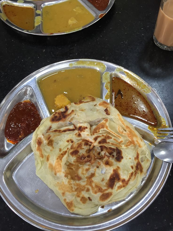 two plates with different types of food on them and sauces in front of them