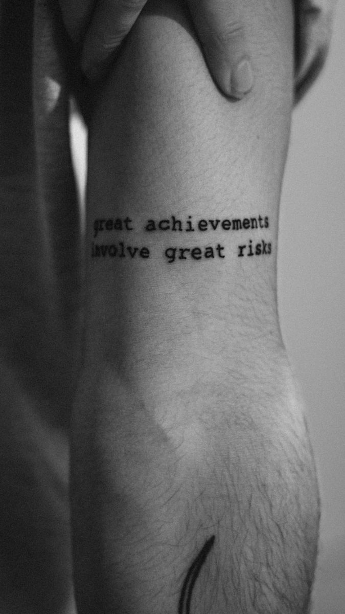 a person with a tattoo on their arm that reads, great achievement involves great ritual