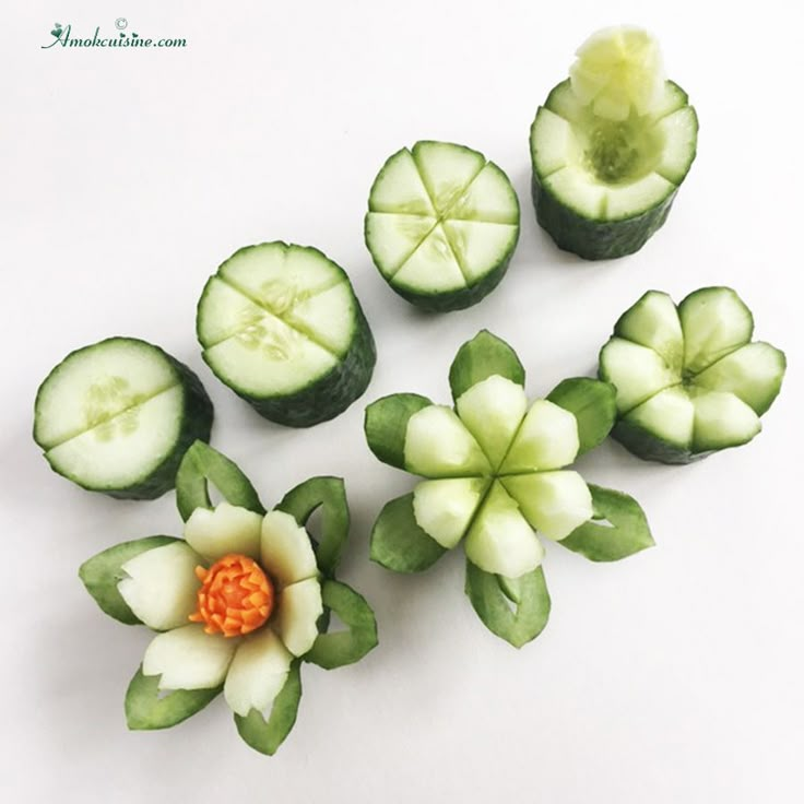 cucumbers with leaves and flowers on a white table top, ready to be cut into small pieces